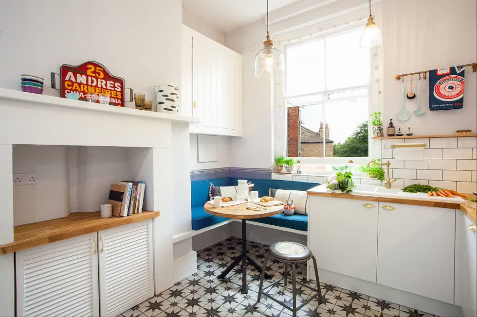   Ghế bành màu xanh bên trong nhà bếp chiết trung nhỏ thêm màu sắc trong khi tận dụng không gian góc.  
