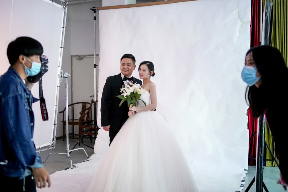   Cô dâu Peng Jing  24 tuổi là một lễ tân, còn chú rể 28 tuổi tạo dáng chụp ảnh cưới sau khi lệnh phong tỏa được dỡ bỏ. Họ cho biết thay vì rình rang, họ sẽ tổ chức đám cưới thật đơn giản. Đây là một đóng góp nhỏ vào nỗ lực kiểm soát dịch bệnh của thành phố trong thời gian qua,  