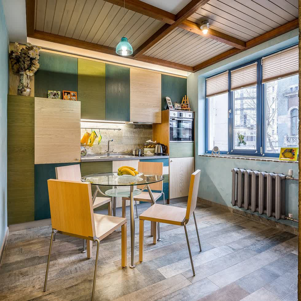  Sắc thái của màu xanh lá cây và màu vàng kết hợp với gỗ bên trong nhà bếp nhỏ chiết trung.  