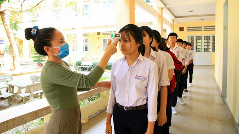 Tiến hành đo thân nhiệt cho học sinh trước khi vào lớp học để đảm bảo an toàn sức khỏe.