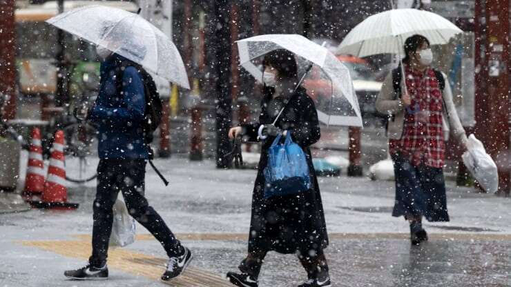 Người dân đeo khẩu trang phòng lây nhiễm virus corona trong tuyết rơi tại Tokyo, Nhật Bản. .