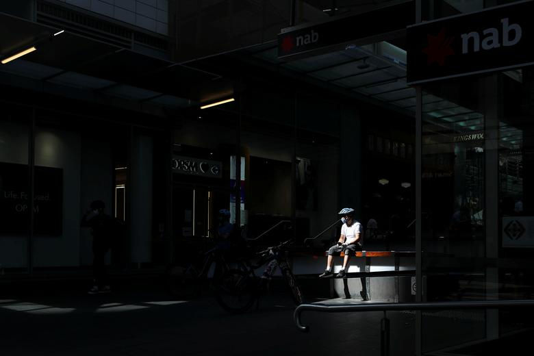 Một người đàn ông giao xe đạp đeo khẩu trang ở Sydney, Australia.