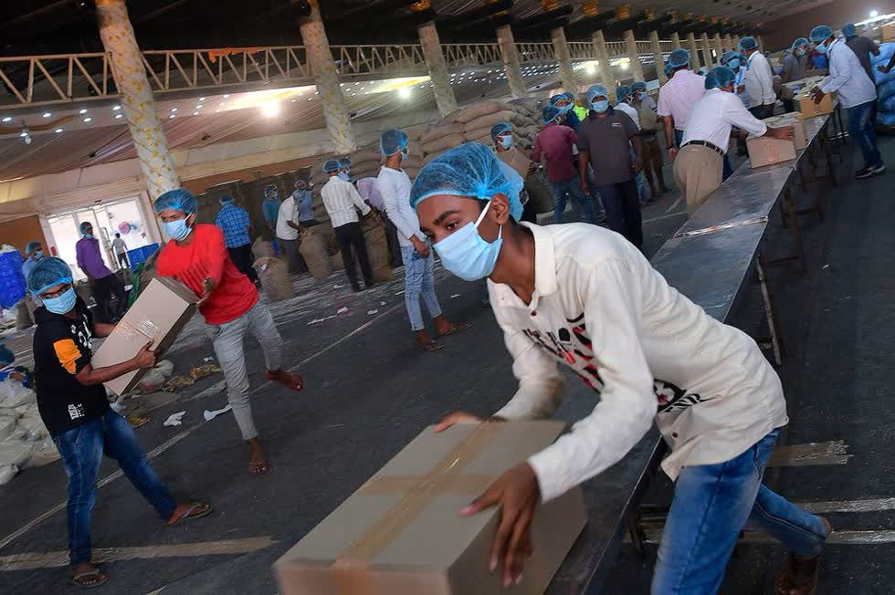   Lao động thất nghiệp vận chuyển nhu yếu phẩm khẩn cấp và cửa hàng tạp hóa để phân phối tại Bangalore, Ấn Độ. Ảnh: AFP.  