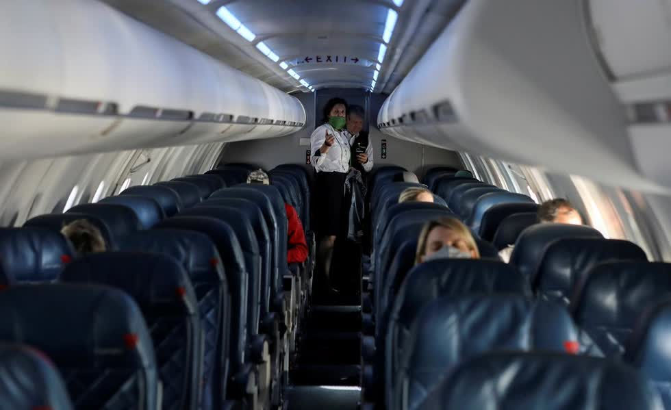 Tiếp viên hàng không nói chuyện trong một cabin gần như trống rỗng trên chuyến bay của Delta Airlines do SkyWest Airlines khai thác khi việc đi lại bị cắt giảm, giữa những lo ngại về bện COVID-19. Ảnh: Reurers.