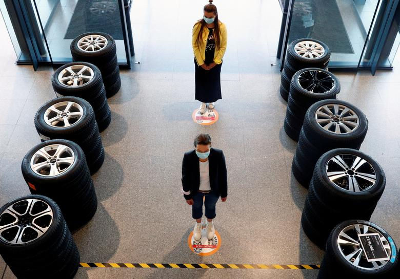     Mọi người đứng trên các điểm đánh dấu để giãn cách xã hội tại một đại lý xe hơi của Mercedes ở Brussels, Bỉ. Ảnh: REUTERS 