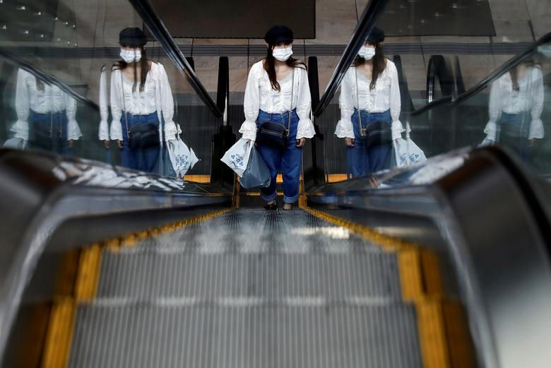     Một người phụ nữ duy nhất sử dụng thang cuốn trong khu thương mại yên tĩnh vào ngày làm việc đầu tiên sau kỳ nghỉ Tuần lễ vàng, tại Tokyo, Nhật Bản. Ảnh: REUTERS  