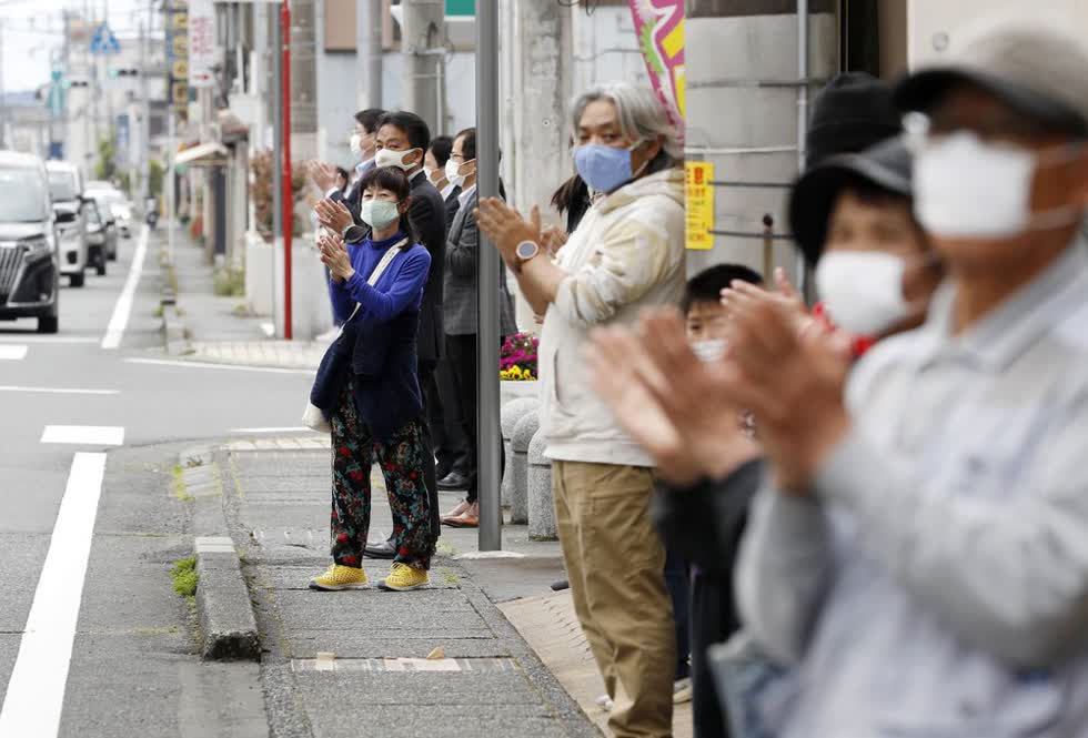 Một nhóm người ở tỉnh Shizuoka đứng trên vỉa hè để vỗ tay thể hiện sự ủng hộ với các nhân viên y tế - hành động rất phổ biến ở châu Âu trong thời kỳ đại dịch. Ảnh: AP.