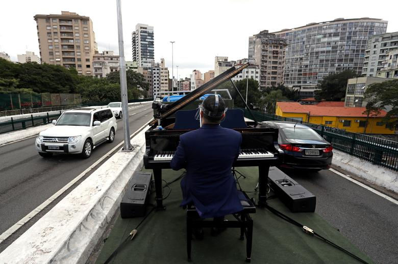   Nghệ sĩ dương cầm Rodrigo Cunha chơi đàn trên một chiếc xe tải nhằm tặng cho những người mẹ cô đơn bị cách ly ở Sao Paulo, Brazil.  