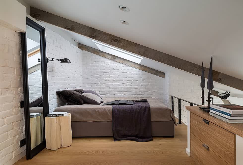 Phòng ngủ gác mái siêu nhỏ với trần dốc và gương lớn giúp nó trông rộng rãi hơn.