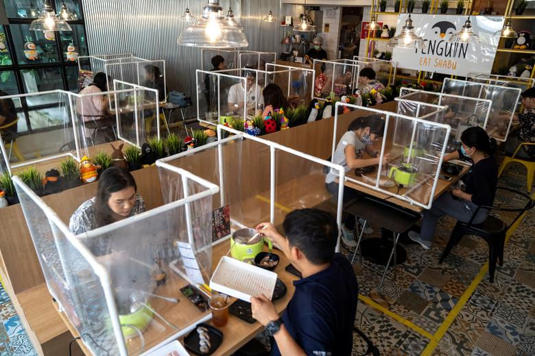   Mọi người dùng bữa trưa tại nhà hàng lẩu Penguin Eat Shabu sau khi nó mở cửa trở lại ở Bangkok, Thái Lan, ngày 8/5. Ảnh: REUTERS  