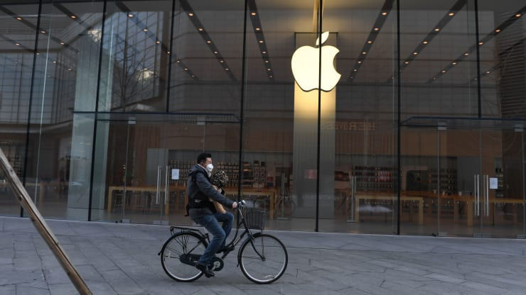 Một người đàn ông đạp xe qua một cửa hàng Apple đã đóng cửa ở Bắc Kinh vào ngày 8/2/2020. Ảnh: AFP.