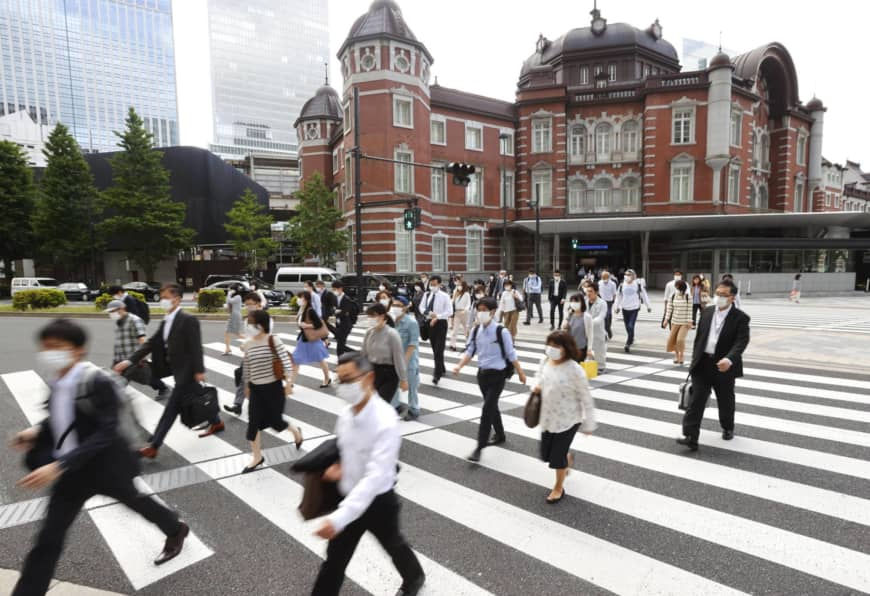   Người đi làm băng qua một con đường bên ngoài ga Tokyo vào sáng hôm nay (25/5), vài giờ trước khi chính phủ chính thức dỡ bỏ tình trạng khẩn cấp ở 5 quận còn lại bao gồm thủ đô Tokyo - tạo tiền đề cho cả nước bước vào giai đoạn tiếp theo trong cuộc chiến chống COVID-19. Ảnh: Kyodo.  