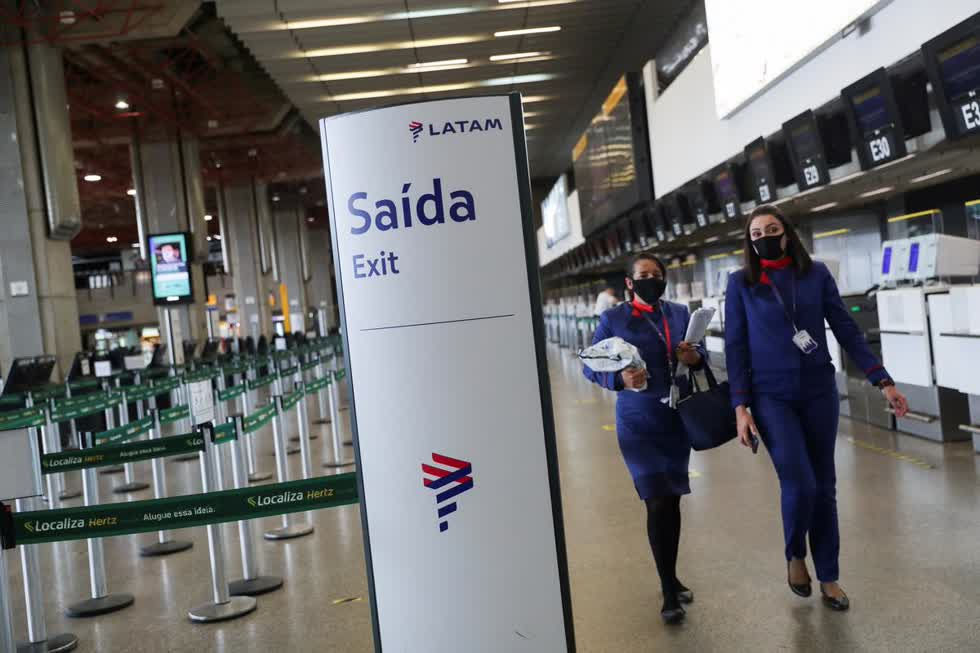  Nhân viên của Latam Airlines đi bộ tại sảnh làm thủ tục của công ty tại sân bay quốc tế Guarulhos vì giao thông hàng không bị ảnh hưởng bởi sự bùng phát của COVID-19, tại Guarulhos, Sao Paulo, Brazil. Ảnh: Reuters.