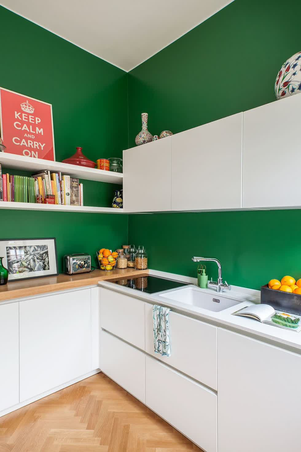   Bức tường màu xanh đậm cho nhà bếp nhỏ theo phong cách Scandinavia với tủ màu trắng.  