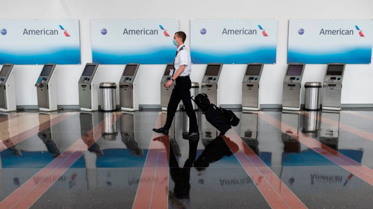   Một nhân viên hàng không đi ngang qua các nhà ga làm thủ tục của American Airlines tại Sân bay Quốc gia Ronald Reagan Washington ở Arlingtonvào ngày 12/5. 