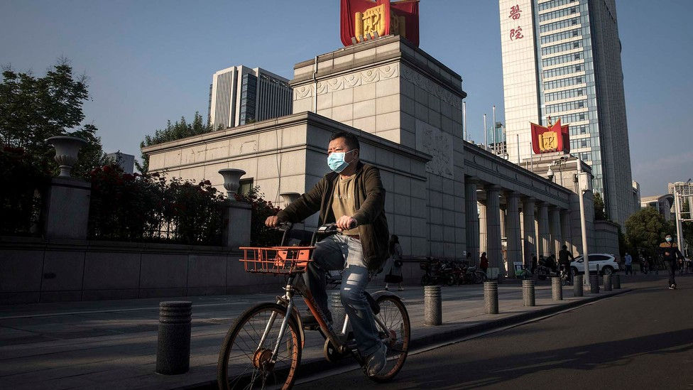 Người dân Trung Quốc đeo khẩu trang phòng dịch COVID-19 khi ra đường. Ảnh: BBC