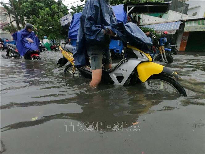 Nước ngập hơn nửa bánh xe trên đường Nguyễn Duy Trinh (quận 2). Ảnh: TTXVN