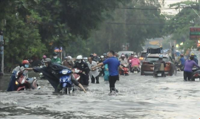 Nhiều tuyến đường ở quận 2 ngập sâu khiến nhiều người dân khó di chuyển. Ảnh: TTXVN.