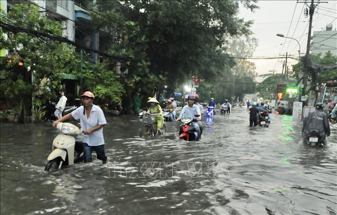   Ngập sâu trên đường Phan Anh (quận 2) khiến người dân phải xuống xe dắt bộ. Ảnh: TTXVN 