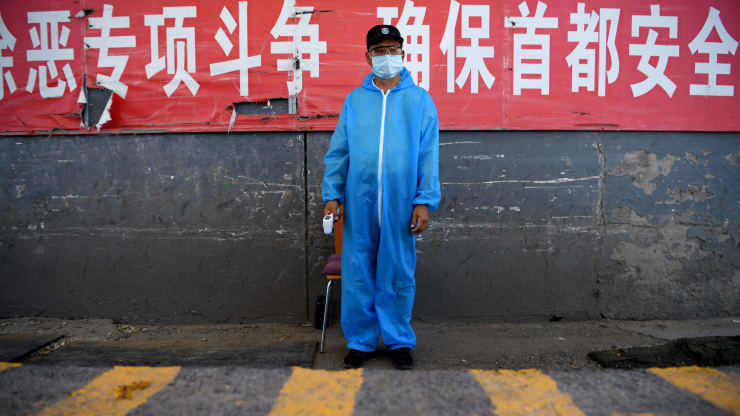   Một nhân viên bảo vệ đeo khẩu trang bảo hộ đứng ở trạm kiểm soát tại chợ đầu mối Tân Phát Địa ở Bắc Kinh vào ngày 14/6. Ảnh: AFP.  