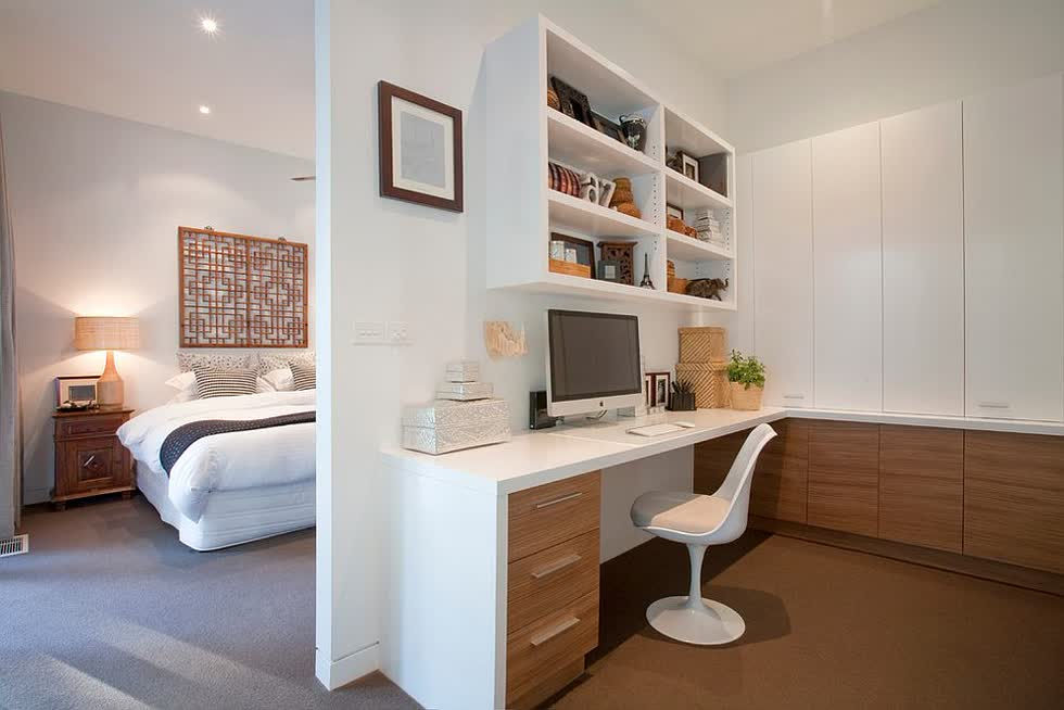 Tủ gỗ mang lại sự ấm áp cho văn phòng màu trắng tại nhà bên cạnh phòng ngủ chính.