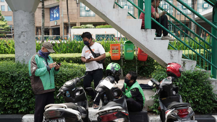 Các tài xế Gojek đeo mặt khẩu trang bảo vệ đợi khách hàng dọc đường ở Jakarta, Indonesia vào ngày 22/4. Ảnh: Bloomberg.