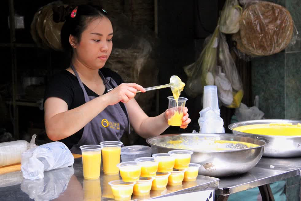   Người bán hàng liên tục đóng sẵn các chén chè đậu xanh.  