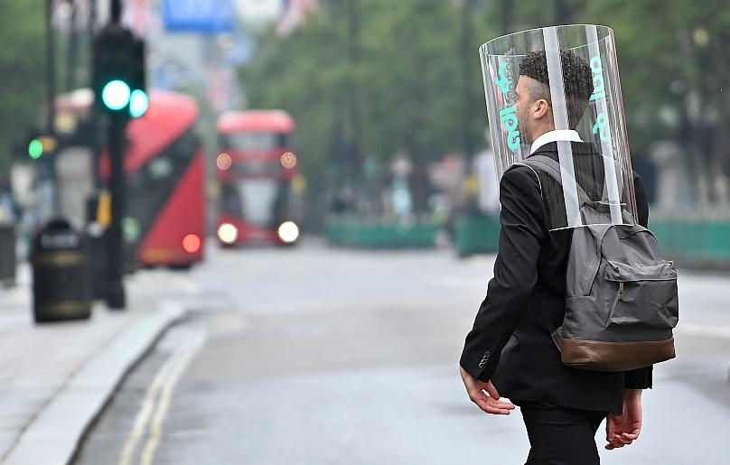 Một người đi bộ mang một thiết bị bảo vệ cá nhân như một biện pháp phòng ngừa chống lại COVID-19, đi bộ qua đường Oxford ở London, Vương quốc Anh. Ảnh: AFP.