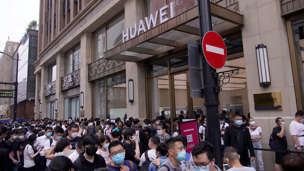 Hàng dài người nối người đứng trước cửa hàng Huawei đợi thời khắc khai trường. Ảnh: Reuters