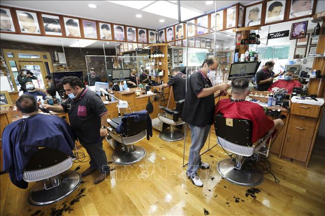 Một hiệu cắt tóc mở cửa phục vụ khách hàng ở New York, Mỹ ngày 22/6. Ảnh: TTXVN