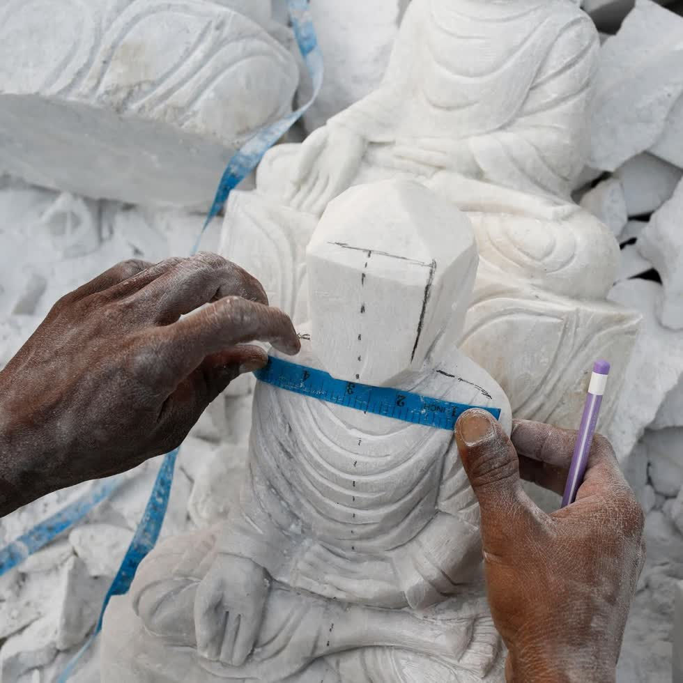    Một thợ chạm khắc đá cẩm thạch thực hiện các phép đo của một mảnh đá cẩm thạch khi anh ta chạm khắc một bức tượng Phật giáo, (ảnh trái) và các bức tượng bằng đá cẩm thạch được bày bán trong một cửa hàng (ảnh phải).  