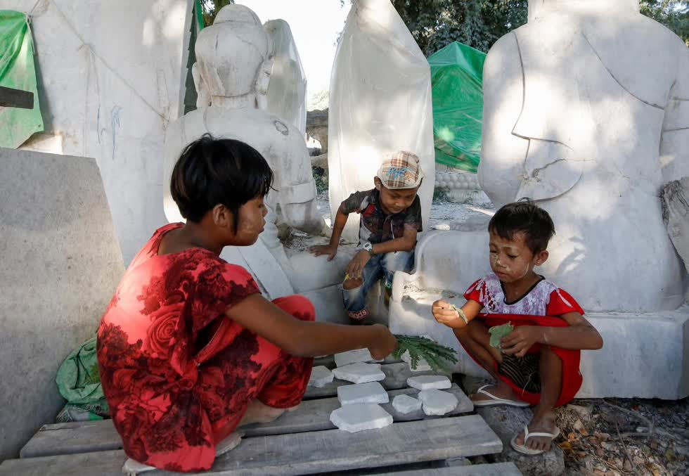   Trẻ em chơi với những mảnh đá cẩm thạch tại một xưởng chạm khắc.  