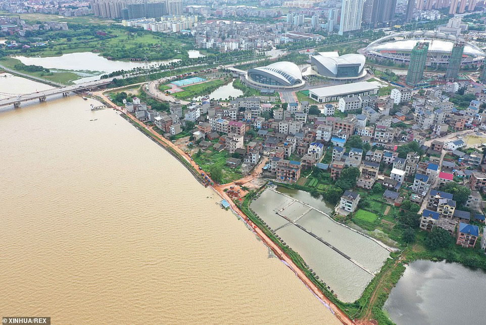   Một bức ảnh chụp từ trên không vào ngày 11/7 cho thấy mọi người gia cố đê chống thấm tạm thời để ngăn chặn lũ lụt tại làng Jiangjialing ở huyện Poyang, phía đông tỉnh Giang Tây của Trung Quốc. Giang Tây là một trong những tỉnh chịu ảnh hưởng nặng nề nhất của  lũ lụt ở Trung Quốc  trong tháng này.  