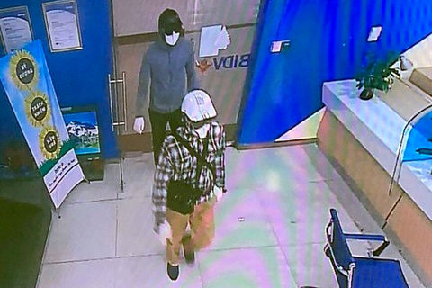   Hình ảnh 2 nghi phạm che gần kín mặt, đội mũ bảo hiểm đi vào khu vực ngân hàng BIDV. (Ảnh: Zing).  