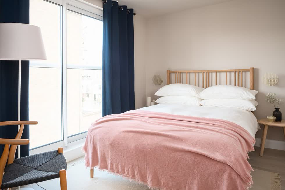   Rèm màu xanh hải quân và ga trải giường màu hồng mang đến cái nhìn mới lạ, cuốn hút hơn cho phòng ngủ phong cách Bắc Âu.  