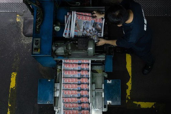 Một nhân viên kiểm tra chất lượng in các trang của tờ Apple Daily vào ngày 11 tháng 8. Người chụp ảnh: Roy Liu / Bloomberg