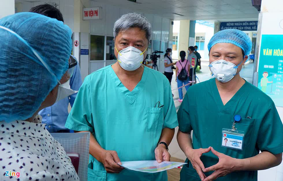 Thứ trưởng Bộ Y tế Nguyễn Trường Sơn trao giấy chứng nhận xuất viện cho 10 bệnh nhân đã được chữa khỏi COVID-19. Ảnh: Zing