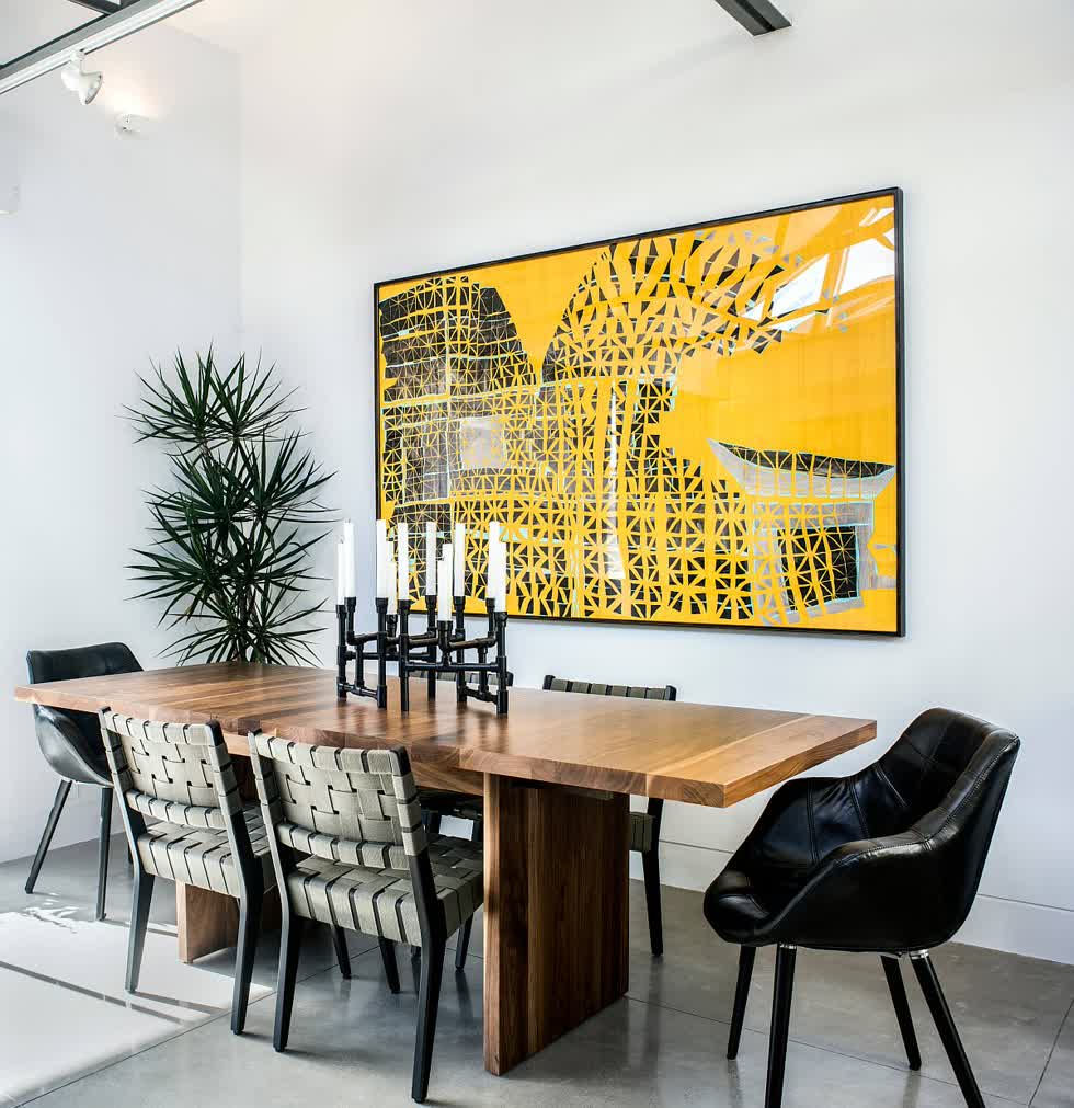 Nghệ thuật tranh treo tường trong phòng ăn này thêm màu vàng sáng vào không gian đen trắng.