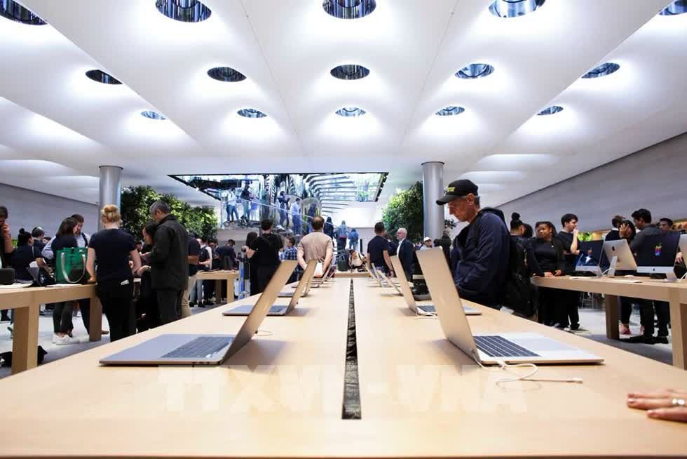   Khách hàng trải nghiệm các sản phẩm của Apple tại cửa hàng ở New York, Mỹ. Ảnh: AFP/ TTXVN  