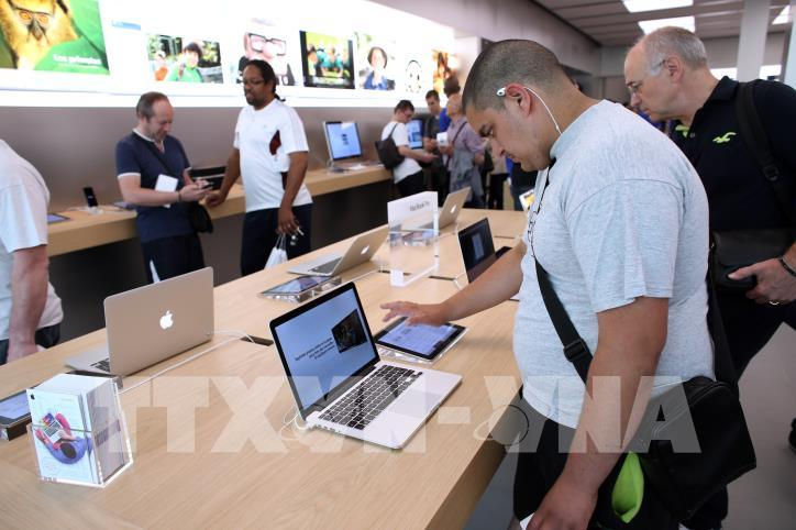   Khách hàng trải nghiệm máy tính MacBook tại cửa hàng của Apple tại Rosny-sous-Bois, gần Paris, Pháp. Ảnh: AFP/ TTXVN   