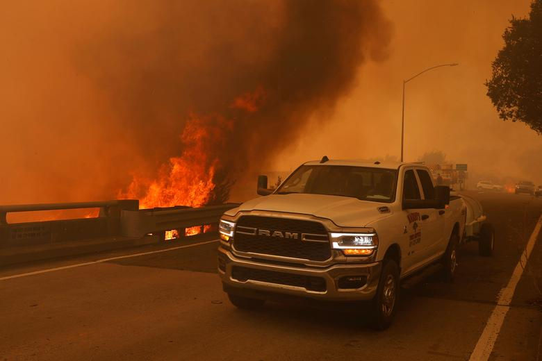   Một chiếc xe bán tải đang đậu trên cầu vượt xa lộ khi ngọn lửa bùng phát lên từ khu vực Liên tiểu bang 80 ở ngoại ô Vacaville, California. Ảnh: Reuters.