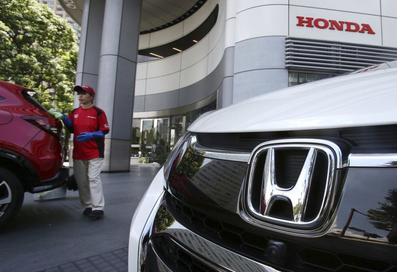 Nhân viên của Honda Motor Co. đang lau một chiếc ô tô Honda trưng bày tại trụ sở chính ở Tokyo vào năm 2018. Ảnh: AP.