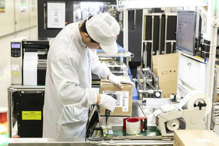 Một kỹ thuật viên quét mã trên dây chuyền lắp ráp của một nhà máy điện thoại di động Huawei ở Đông Quan. Ảnh: Bloomberg.