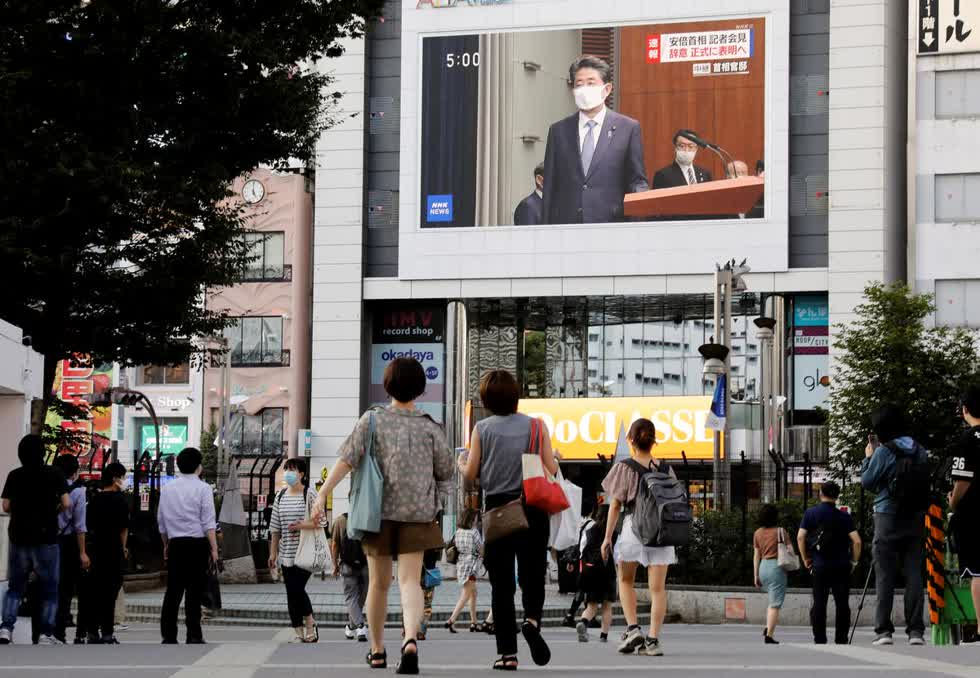 Người dân đeo khẩu trang bảo vệ xem buổi phát sóng cuộc họp báo của Thủ tướng Nhật Bản Shinzo Abe tại Tokyo, Nhật Bản vào chiếu 28/8. Ảnh: Reuters.