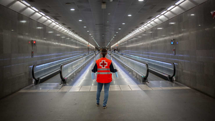 Một tình nguyện viên của Hội Chữ thập đỏ mang khẩu trang cho những người đi làm tại nhà ga Diagonal vào ngày làm việc đầu tiên ở Cataluña tại Barcelona, ​​Tây Ban Nha. Ảnh: David Zorrakino