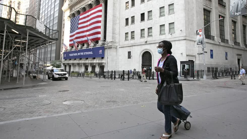 Một phụ nữ đi ngang qua Sở giao dịch chứng khoán New York vào ngày 9/7. Ảnh: AP.