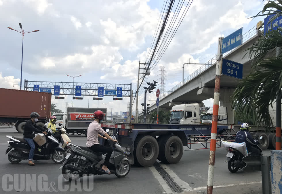 Cảnh xe máy xen kẽ container qua nút giao Xa lộ Hà Nội và đường Số 1 (phường  Trường Thọ ).