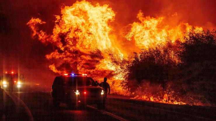   Một nhân viên thực thi pháp luật chứng kiến ​​ngọn lửa bay lên không trung khi lửa tiếp tục lan rộng tại đám cháy Bear ở Oroville, California vào ngày 9/9. Ảnh: CNBC.  