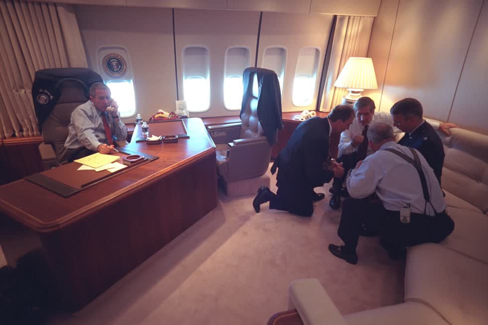 Cựu Tổng thống George W. Bush trao đổi qua điện thoại trong khi các nhân viên cấp cao đang bàn bạc trên chiếc chuyên cơ Không lực Một. Không ai biết rằng còn bao nhiêu chiếc máy bay bị cướp nữa sẽ tấn công vào Thủ đô. Sở Mật vụ cho rằng việc đưa Tổng thống quay lại Washington là điều cực kỳ nguy hiểm. Ảnh: Cục Lưu trữ Quốc gia  Mỹ .