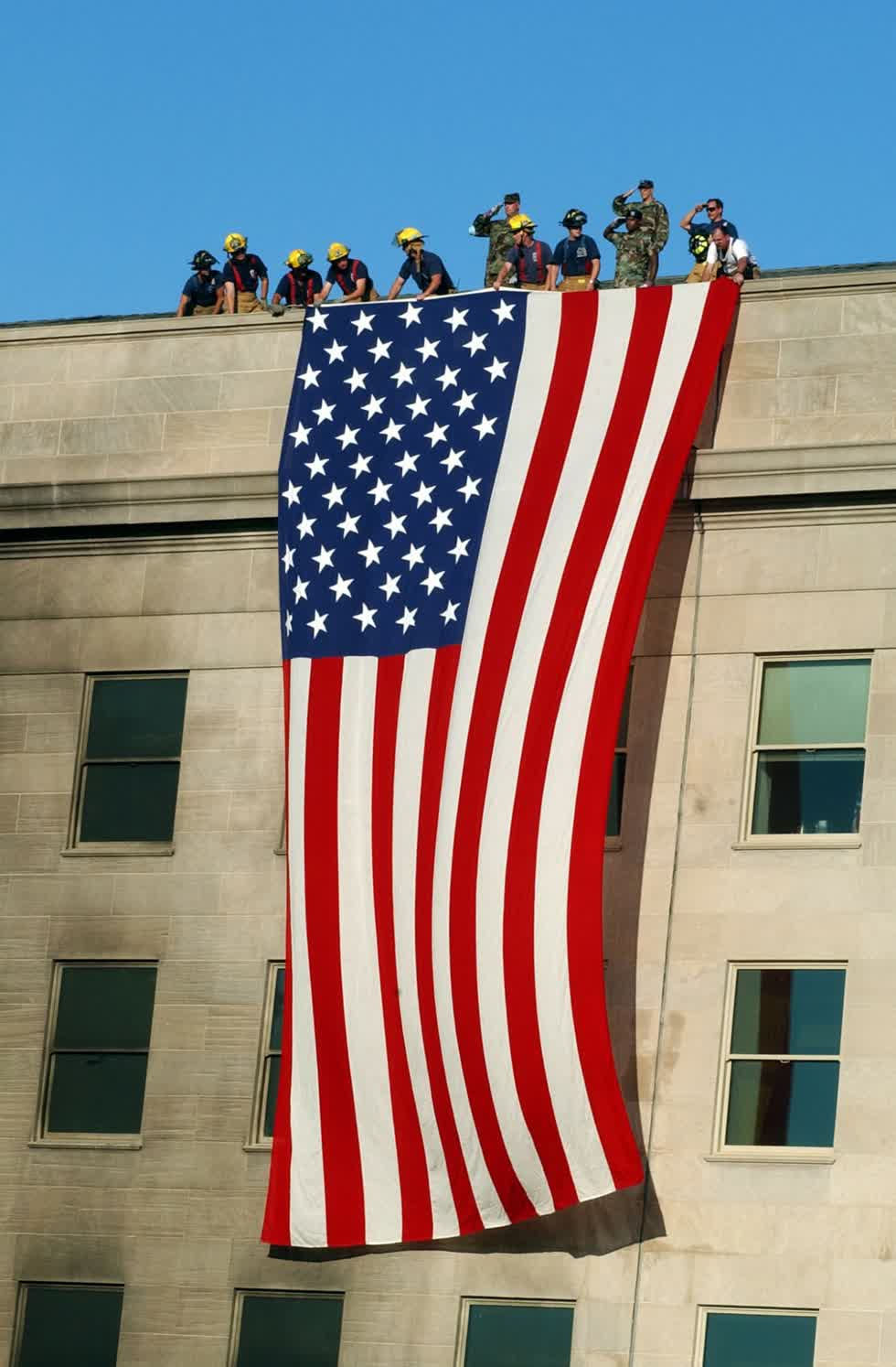 Lính cứu hỏa và binh lính kéo một lá cờ Mỹ lớn bên hông Lầu Năm Góc trong nỗ lực cứu hộ và phục hồi. Ảnh: Reuters/Corbis